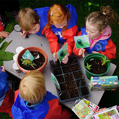 孩子们玩土壤和植物