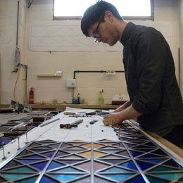 工作人员爱德华·里斯-琼斯正在组装彩色玻璃窗。