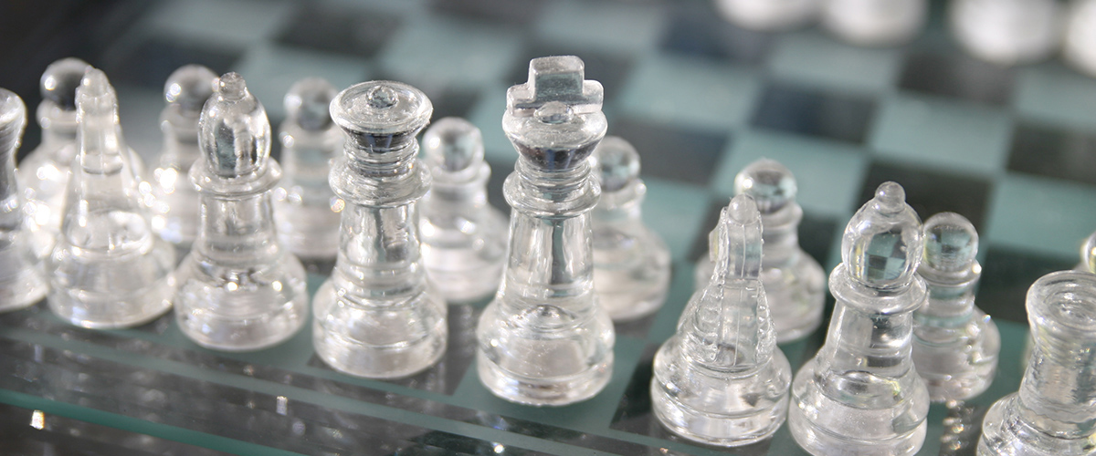 透明的玻璃棋子站在棋盘的起始位置。