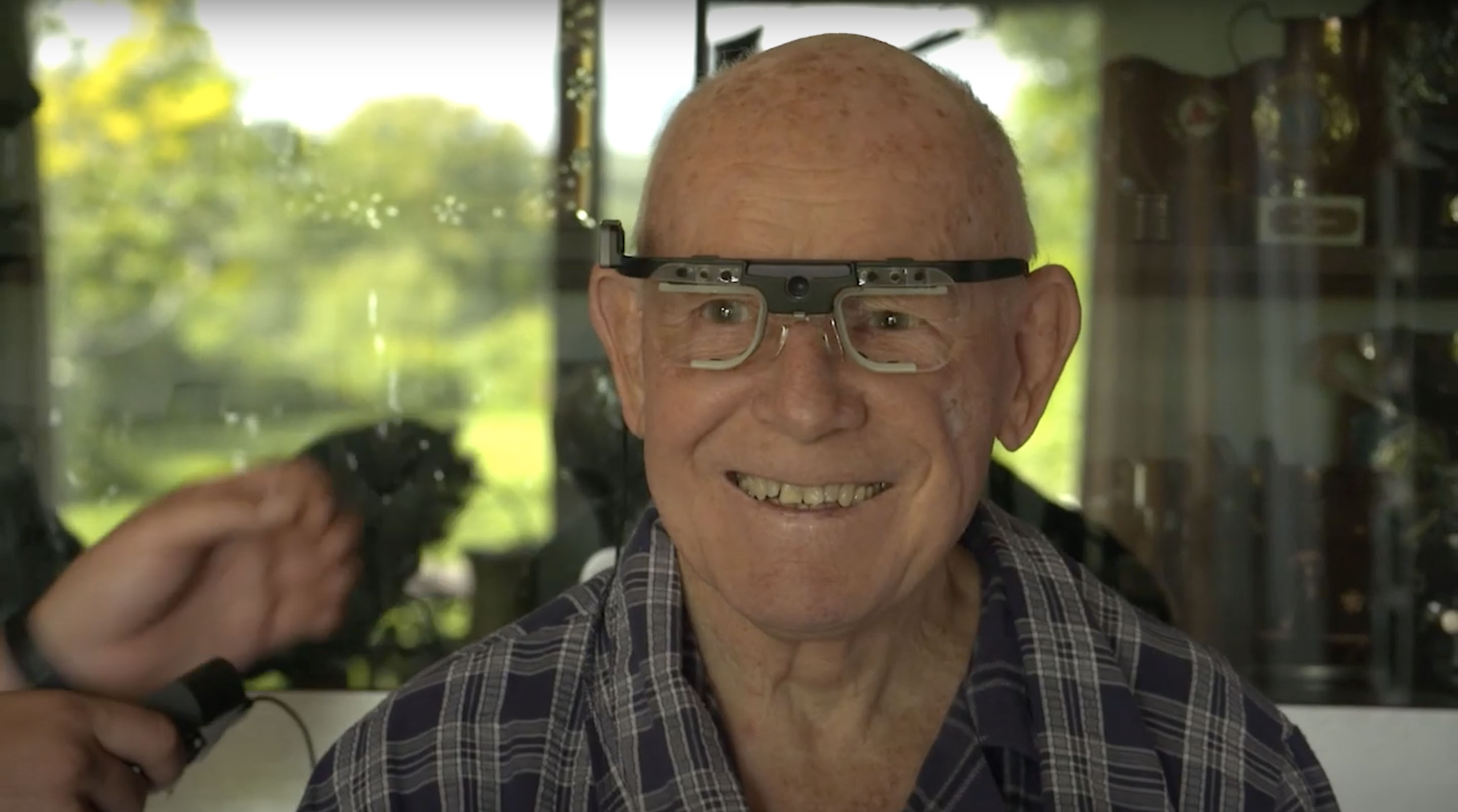 克莱夫·詹金斯(Clive Jenkins)戴着一副计算机框架眼镜微笑，该眼镜旨在追踪眼球运动。