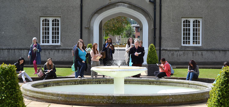 students writing by a fountain