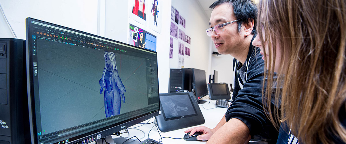 一名导师协助一名学生使用3D图像编辑程序。