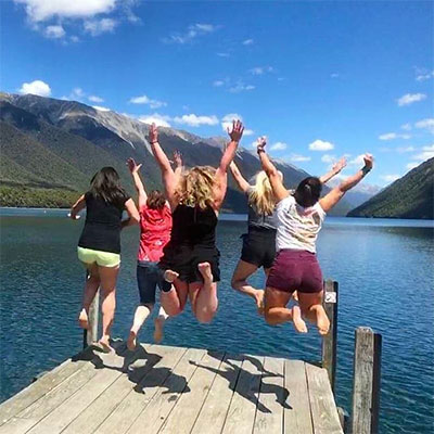 国际学生在湖边跳跃