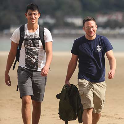 两名国际学生在海滩上行走