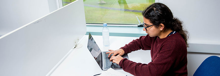 学生坐在书桌前使用电脑