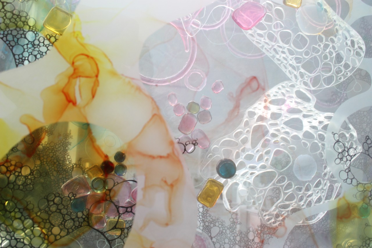 一幅复杂的拼贴画，包括不同的玻璃层、柔和的水色和玻璃珠。